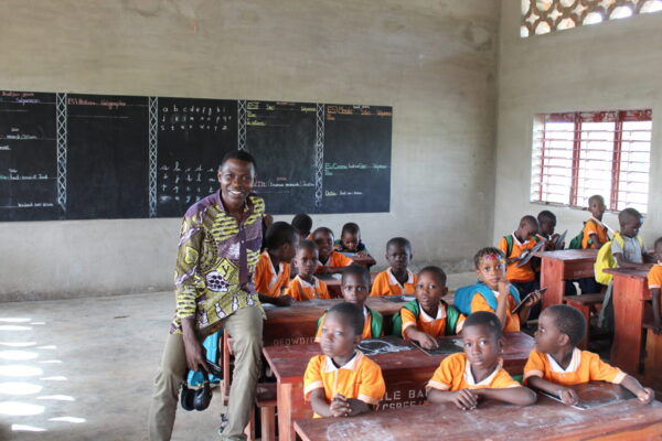 Kinderen en een leraar in een lokaal in Benin.