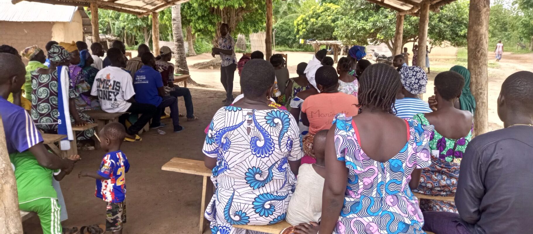 Bijeenkomst in Togo waar inwoners van het dorp voorlichting krijgen over het Waardig werk in de Sahel-programma.